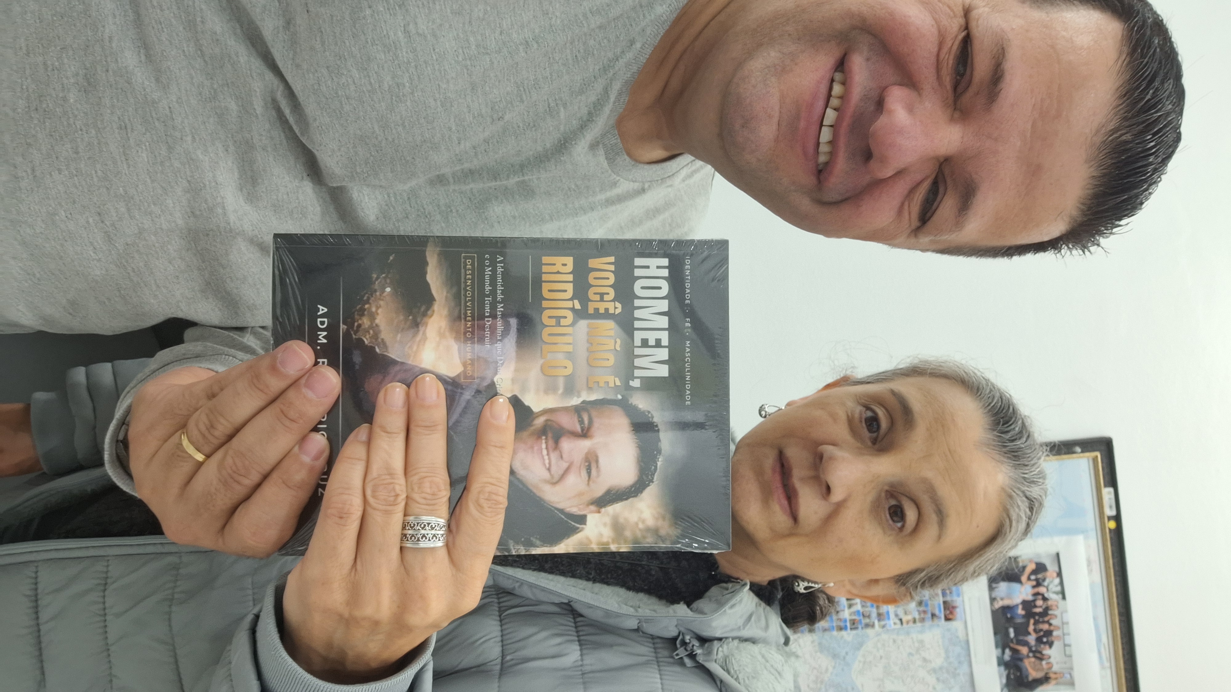 Adm. Romário Cruz com leitor segurando o livro Homem, Você Não É Ridículo