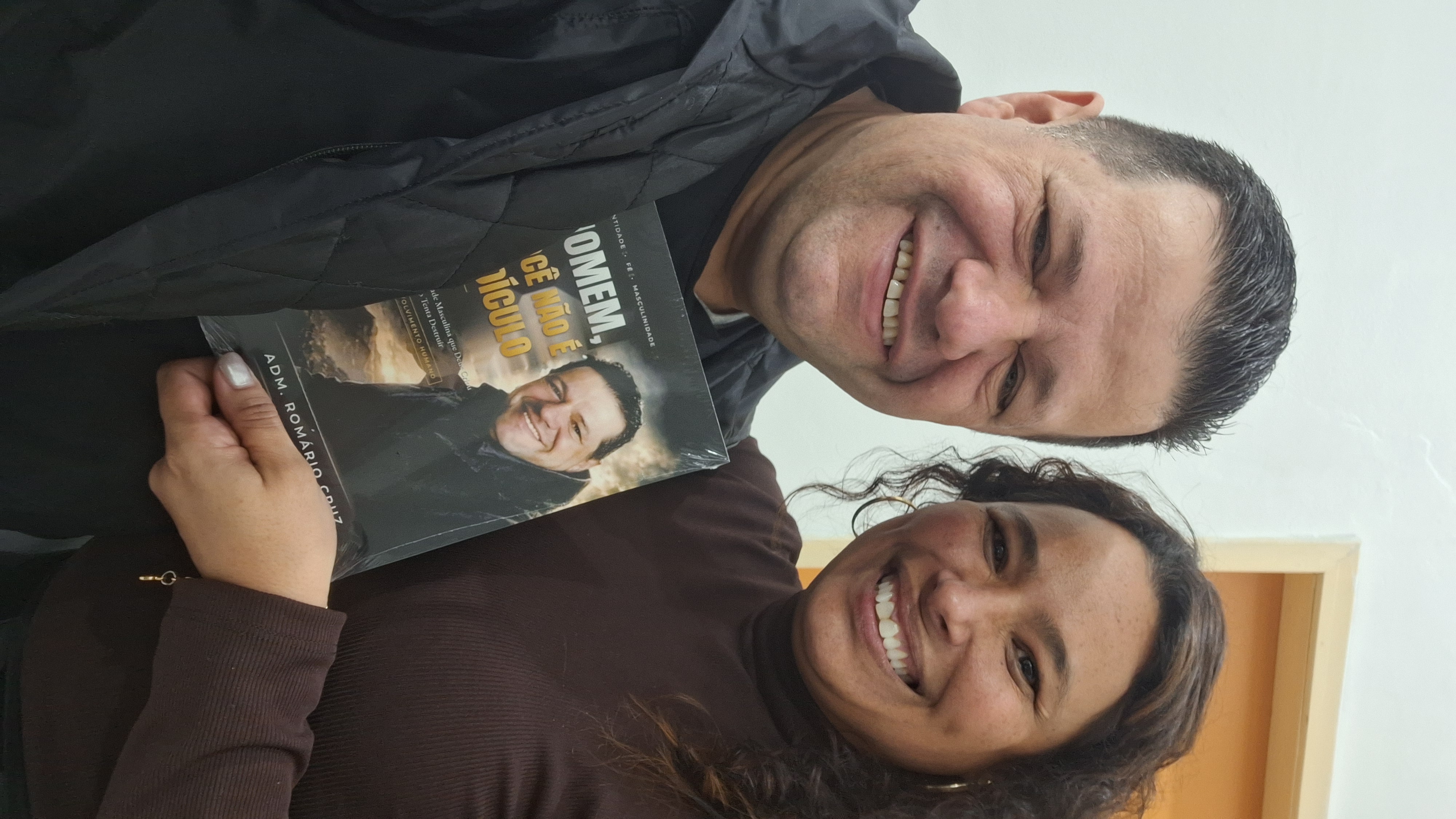 Adm. Romário Cruz com leitor segurando o livro Homem, Você Não É Ridículo
