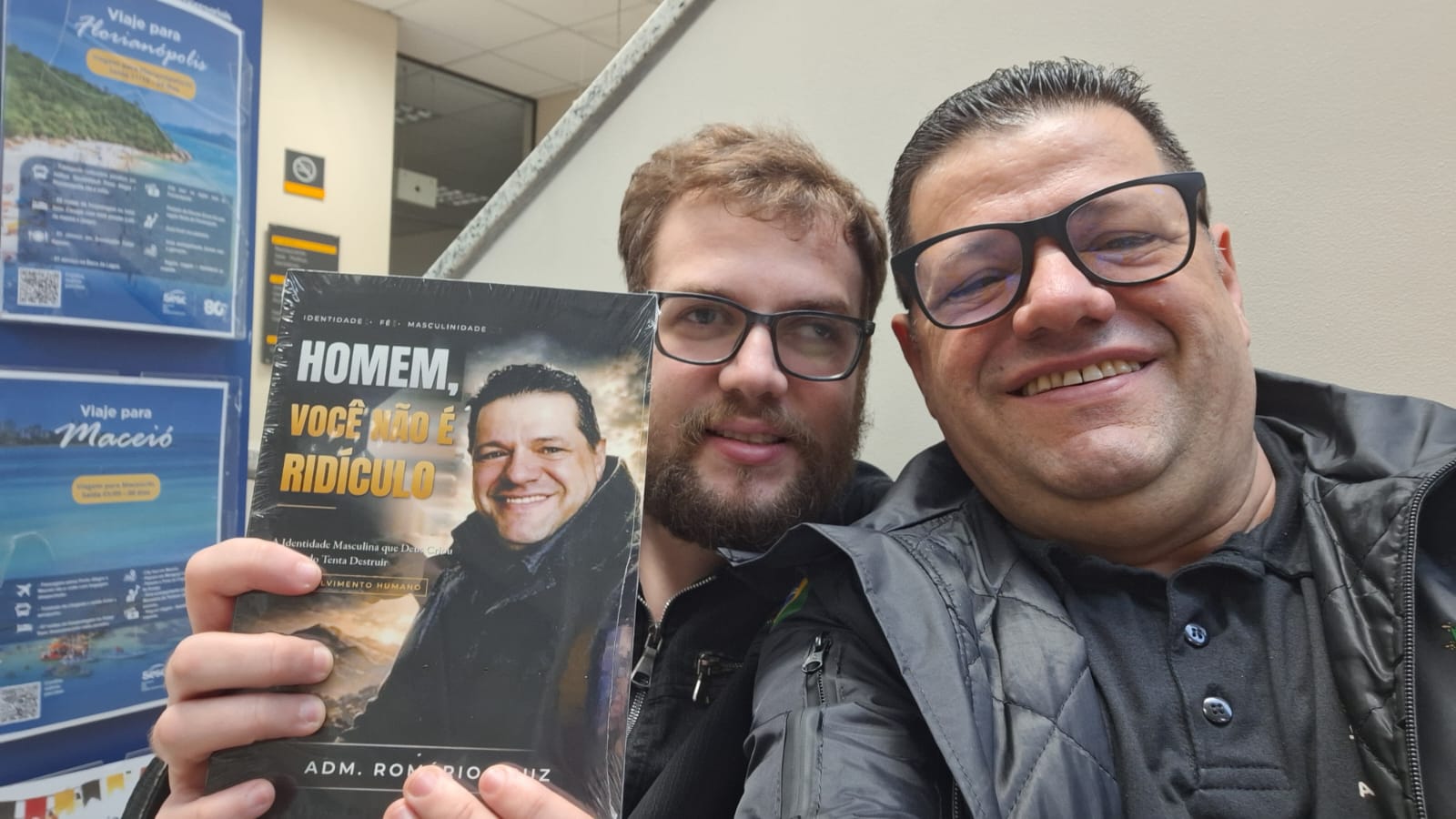 Adm. Romário Cruz com leitor segurando o livro Homem, Você Não É Ridículo