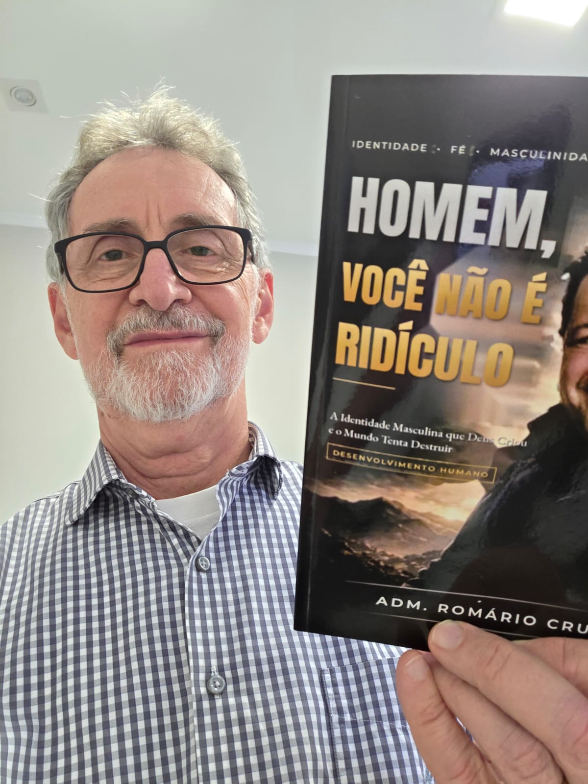 Adm. Romário Cruz com leitor segurando o livro Homem, Você Não É Ridículo