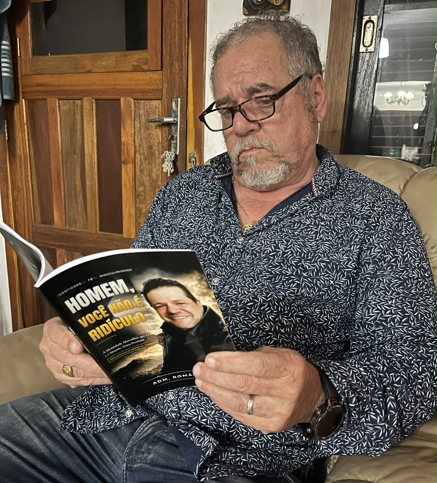Adm. Romário Cruz com leitor segurando o livro Homem, Você Não É Ridículo