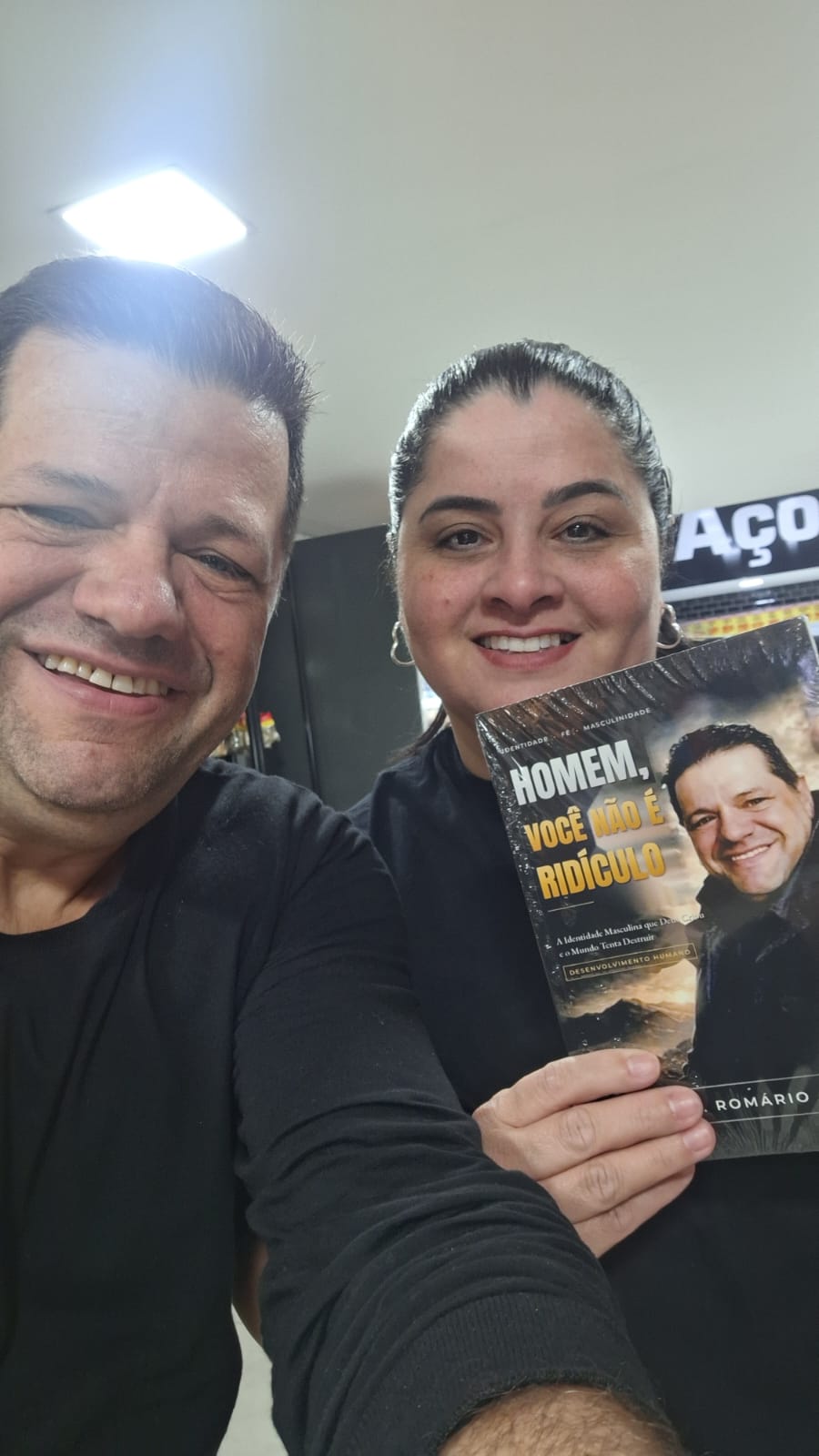 Adm. Romário Cruz com leitor segurando o livro Homem, Você Não É Ridículo