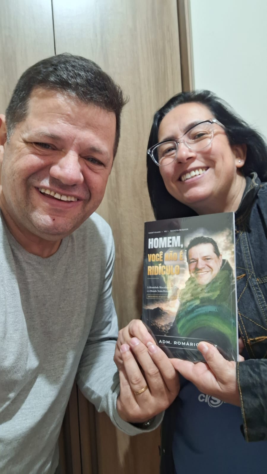 Adm. Romário Cruz com leitor segurando o livro Homem, Você Não É Ridículo