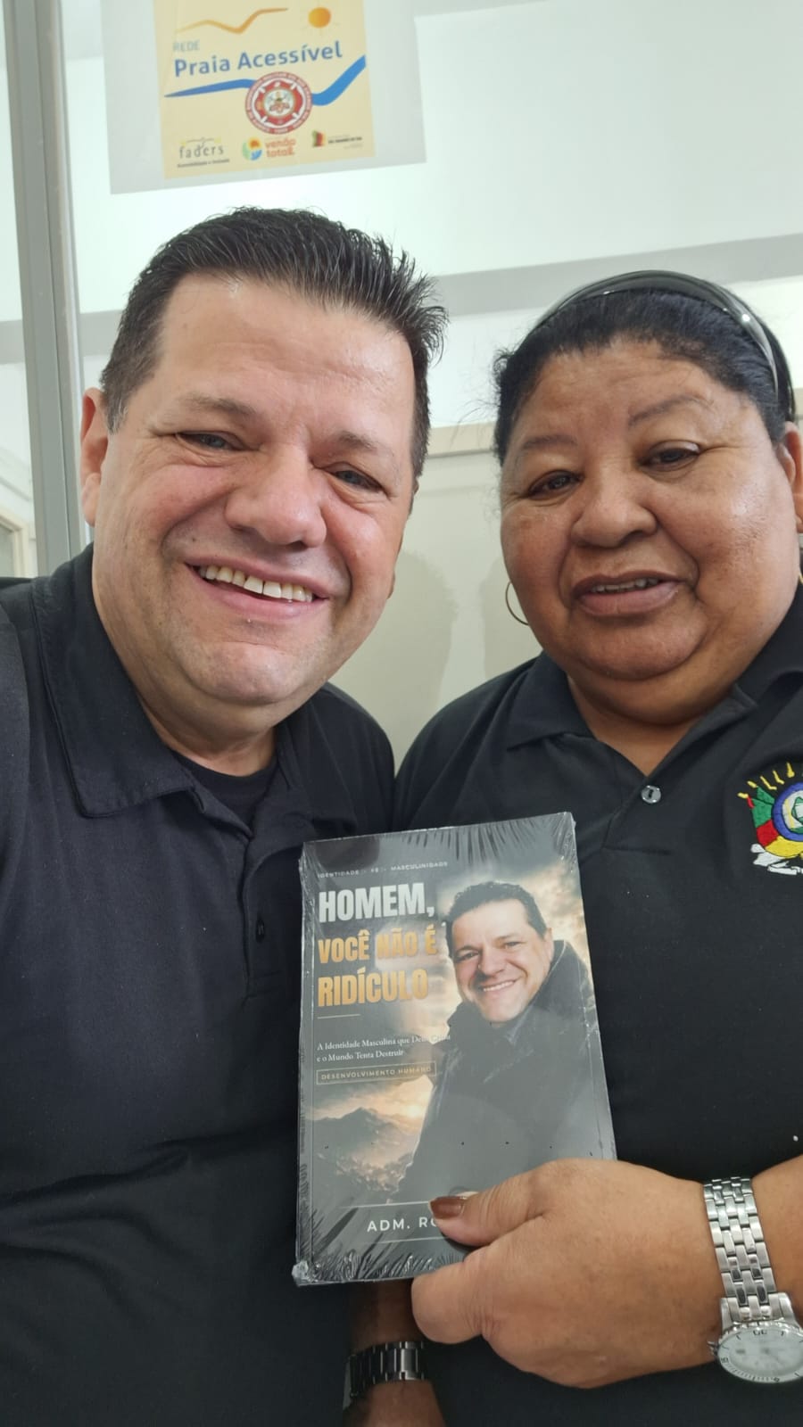 Adm. Romário Cruz com leitor segurando o livro Homem, Você Não É Ridículo