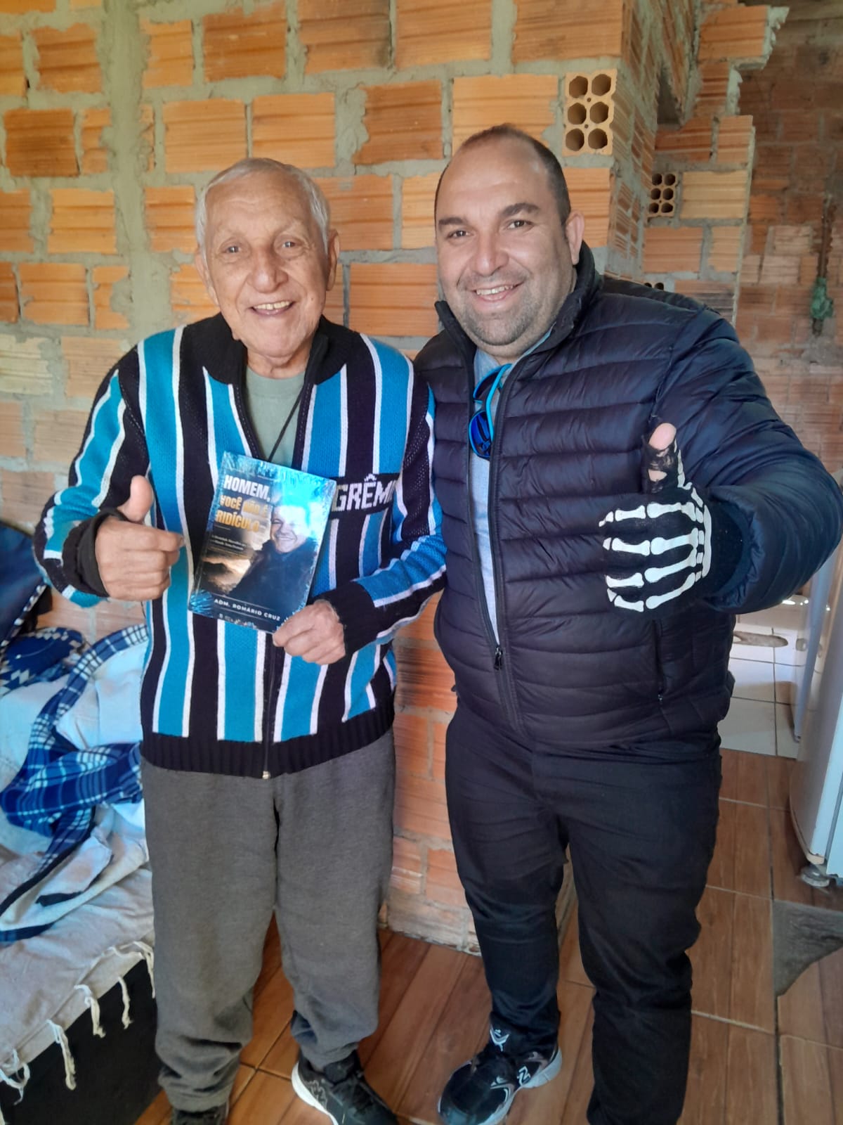 Adm. Romário Cruz com leitor segurando o livro Homem, Você Não É Ridículo