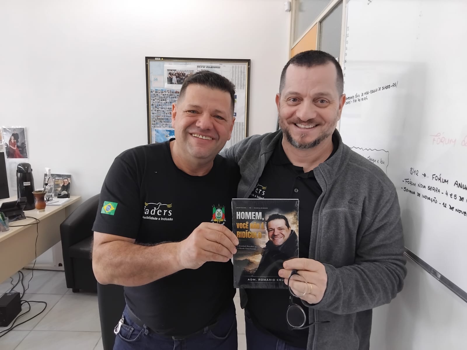 Adm. Romário Cruz com leitor segurando o livro Homem, Você Não É Ridículo