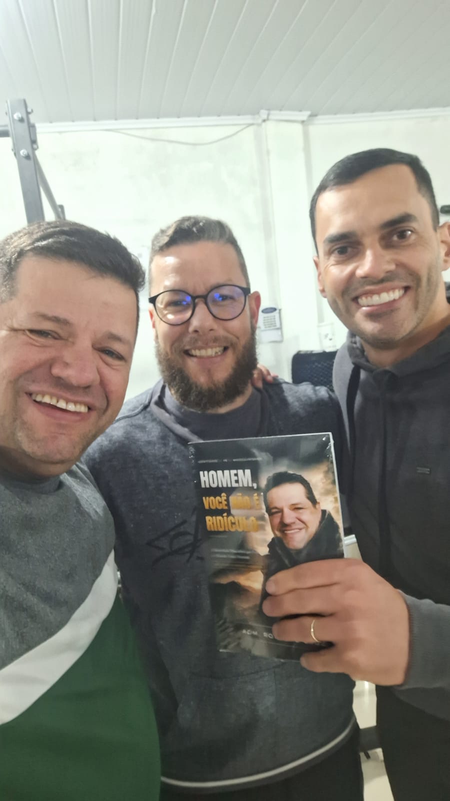 Adm. Romário Cruz com leitores segurando o livro Homem, Você Não É Ridículo