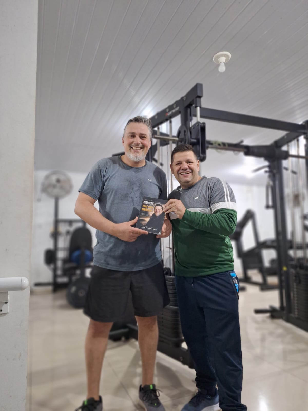 Adm. Romário Cruz com leitor segurando o livro Homem, Você Não É Ridículo