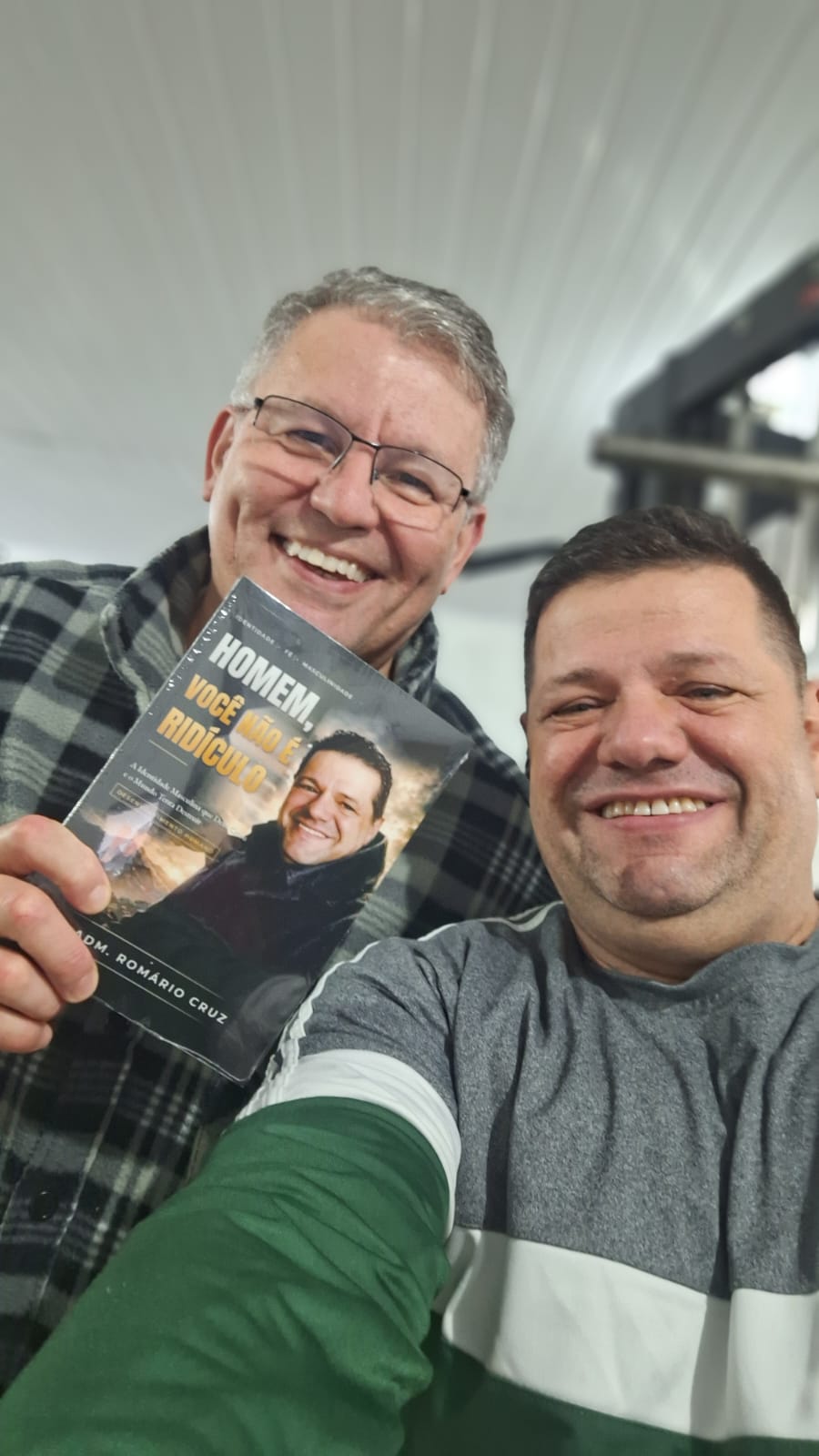 Adm. Romário Cruz com leitor segurando o livro Homem, Você Não É Ridículo