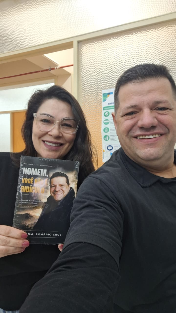 Adm. Romário Cruz com leitora segurando o livro Homem, Você Não É Ridículo