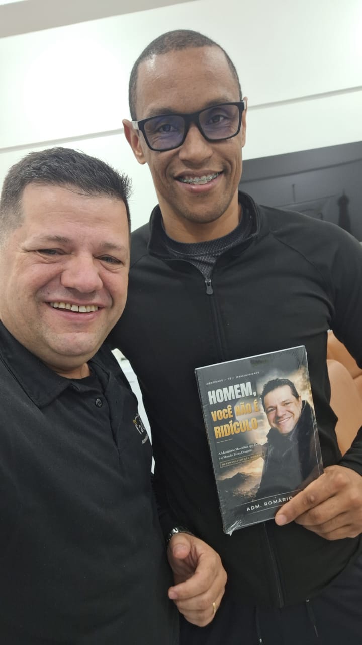 Adm. Romário Cruz com leitor segurando o livro Homem, Você Não É Ridículo