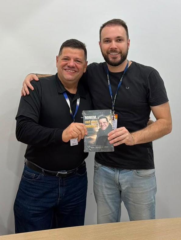 Adm. Romário Cruz com leitor segurando o livro Homem, Você Não É Ridículo