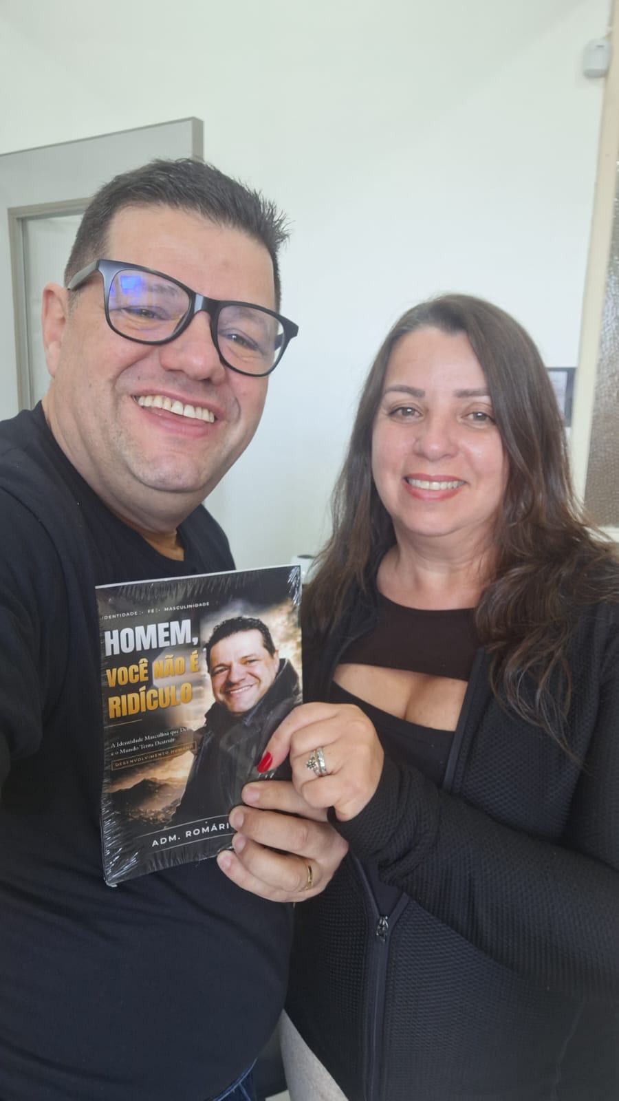 Adm. Romário Cruz com leitora segurando o livro Homem, Você Não É Ridículo