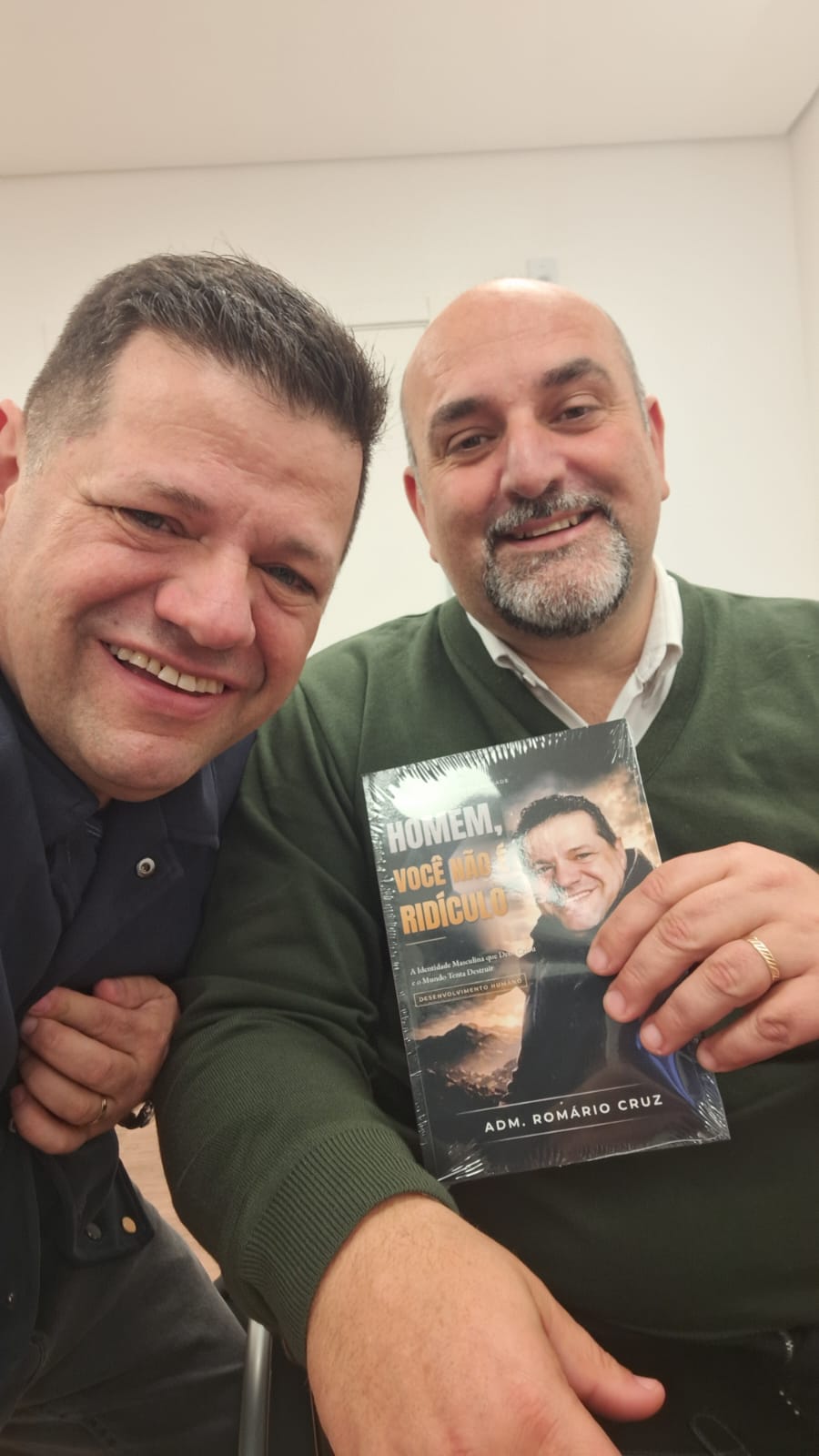 Adm. Romário Cruz com leitor segurando o livro Homem, Você Não É Ridículo