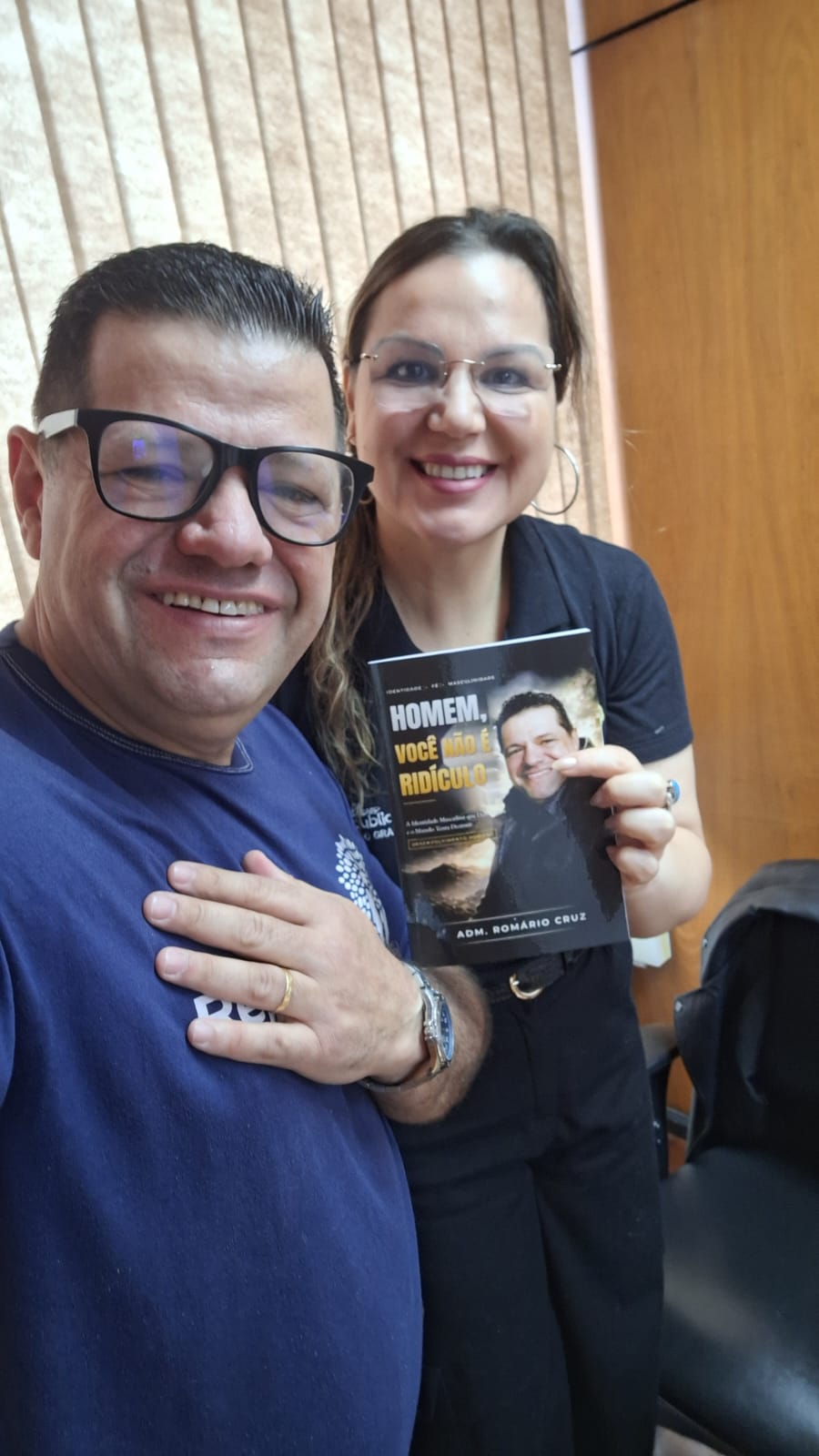 Adm. Romário Cruz com leitora segurando o livro Homem, Você Não É Ridículo